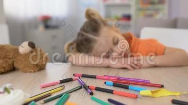 精疲力竭的学龄前儿童睡桌，无聊的班级，小学教育